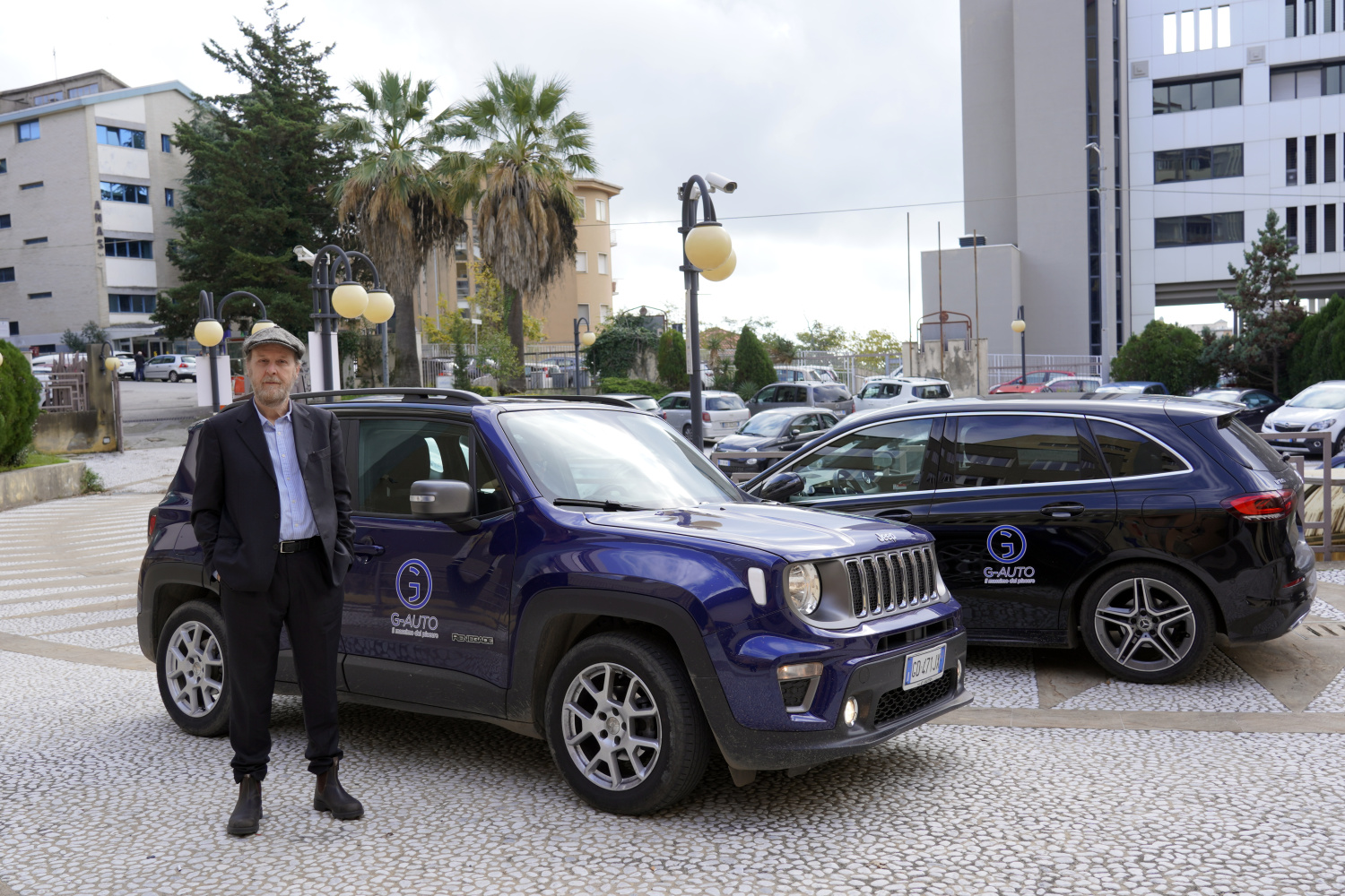 Lo staff G-Auto davanti al concessionario con due veicoli brandizzati